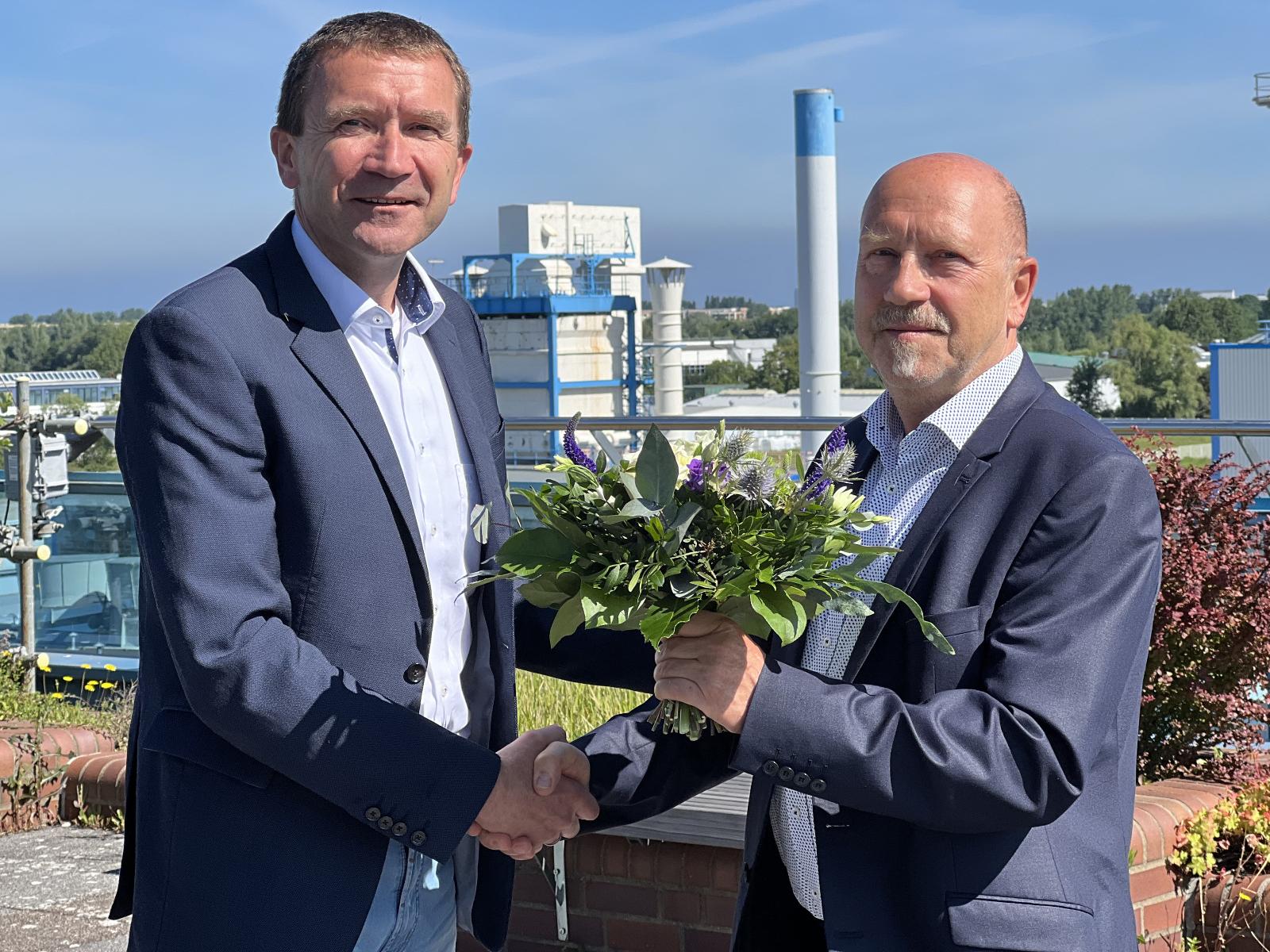 Volker Rattey überreicht Gerald Schubert einen Blumenstrauß und damit symbolisch auch die Geschäfte der Stadtwerke Rostock Netzgesellschaft mbH ab dem 1. Januar 2023.